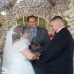 A Hill Country wedding officiant speaking to a bride and groom during their wedding ceremony
