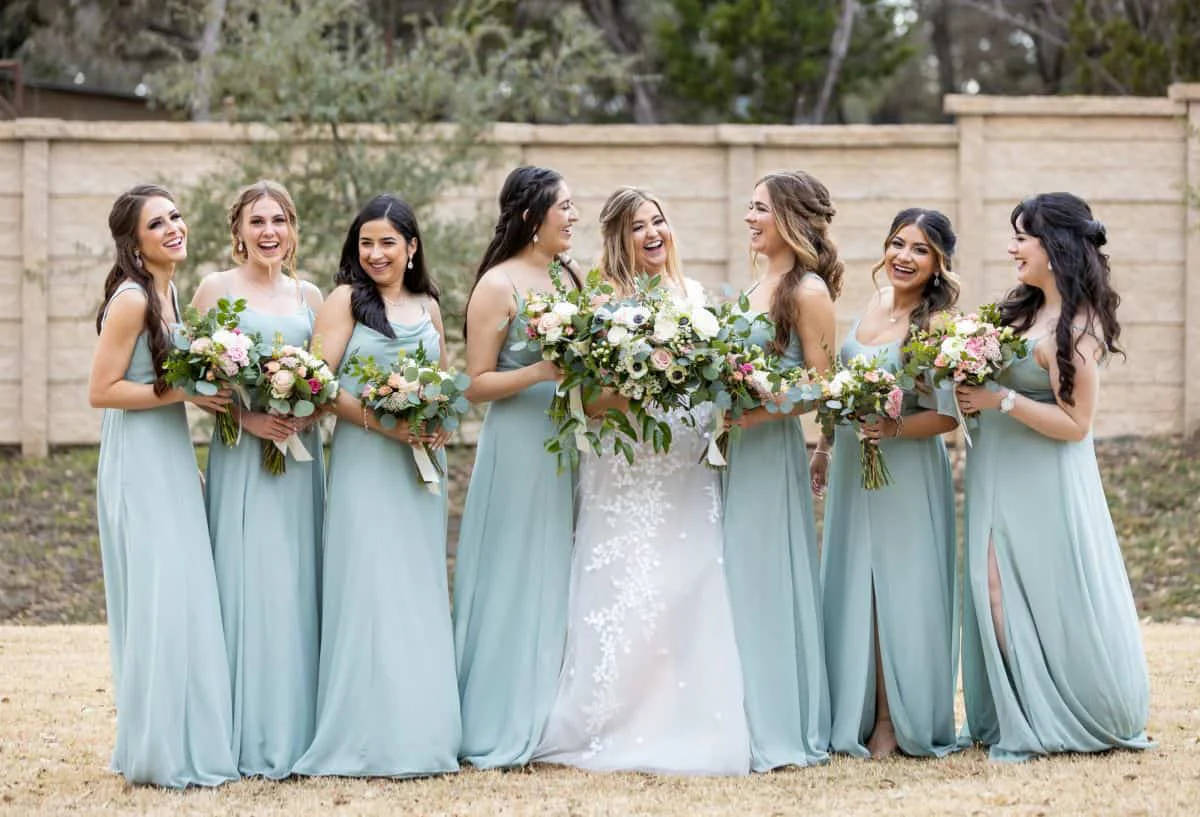 The bride surrounded by her bridesmaids in sage green