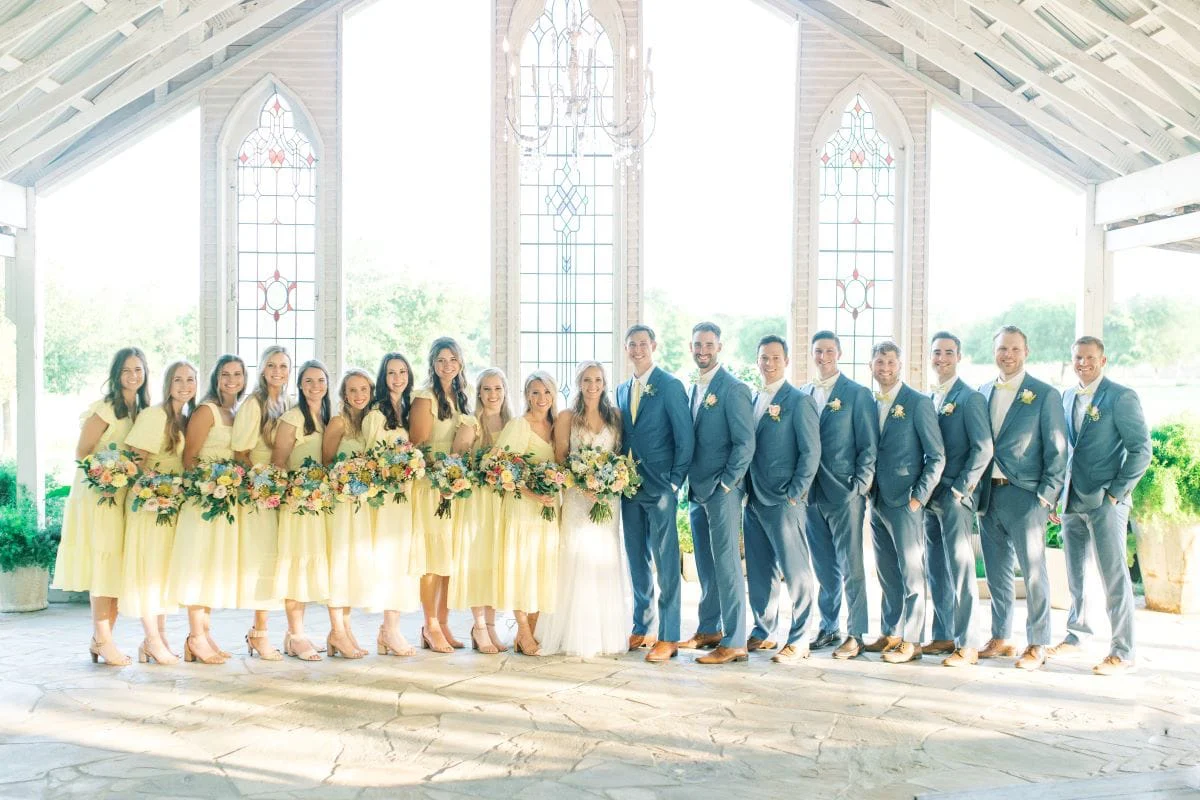 The wedding party in yellow and blue across the chapel floor