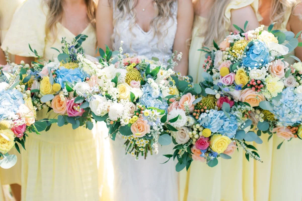 Her bridesmaids in yellow with their pastel spring bouquets