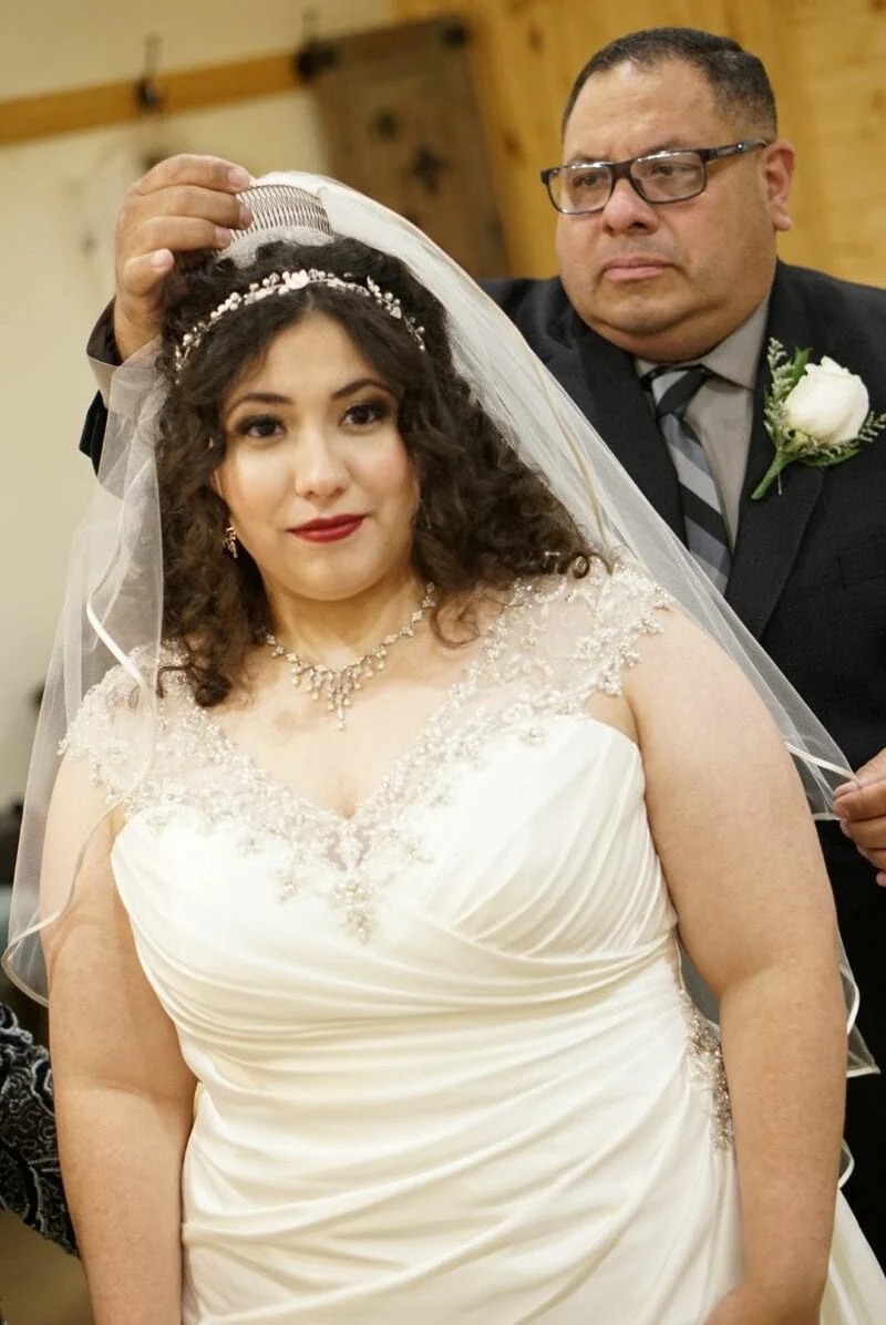 Her veil and headpiece being settled into place before the ceremony