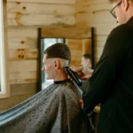 A groom getting his hair done by a Hill Country wedding hair & makeup professional