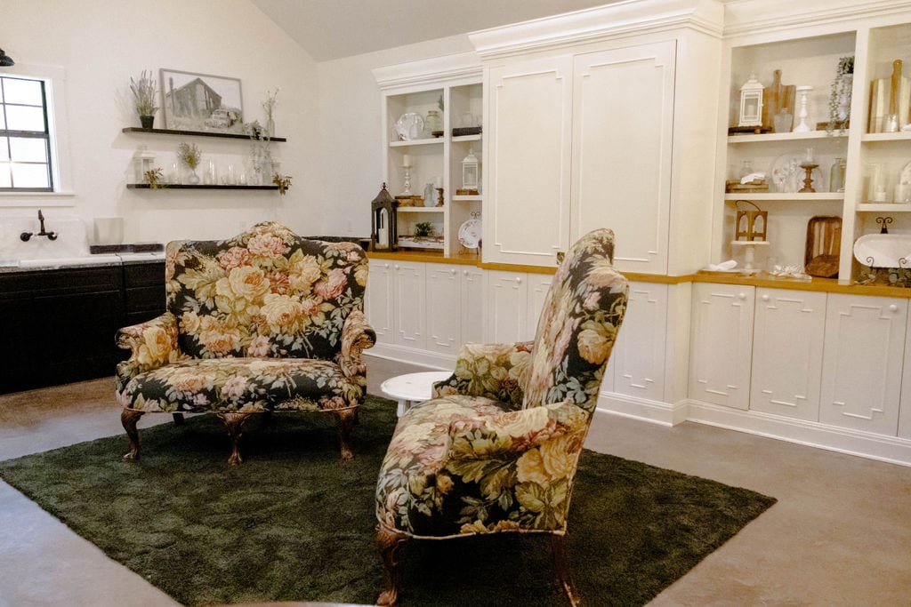 Lounging room with two sofa chairs with white cabinetry and shelving along the wall.