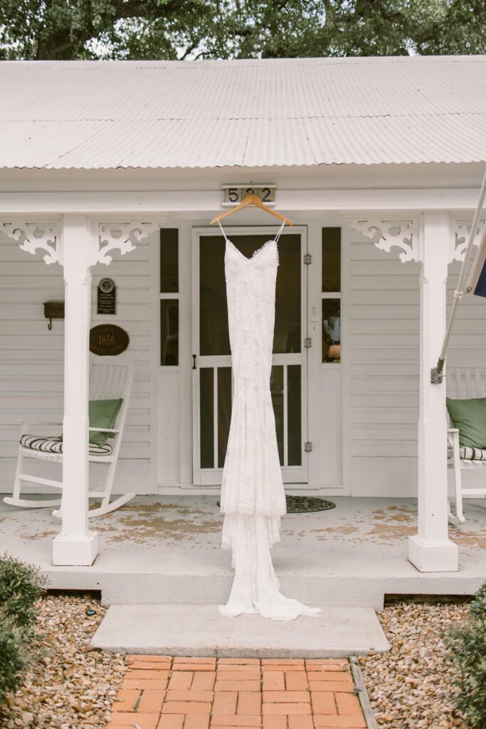 A wedding dress hanging in front of a home