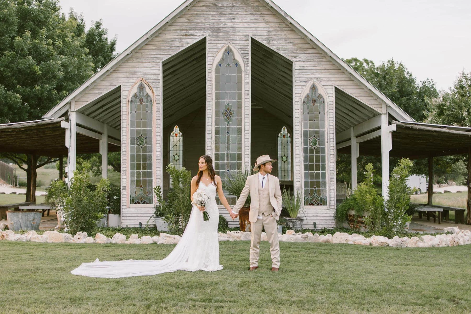 A bride (Taylor) and groom (Jordan) posing in front of a church