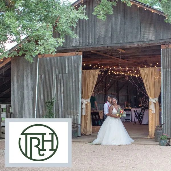 Bride and groom posing in front of the barn at Texas Rock House