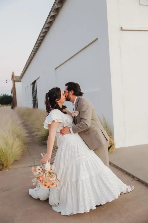 Trey and Carley Schmedt kissing outside Corte del Norte at their Marfa wedding