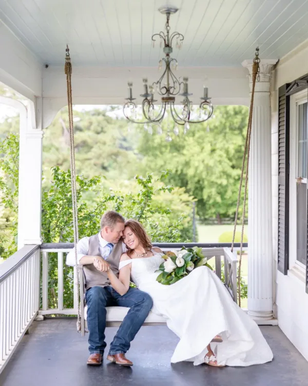 Chad and Brandy Hunt on the porch swing at The Folmar after their East Texas wedding