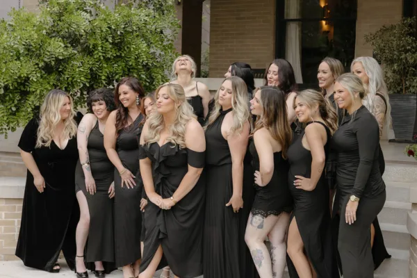 The full Southern Tease team in black dresses posed together on steps