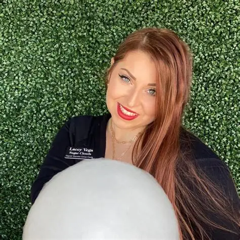 Smiling woman in a Sugar Clouds shirt holding a large cloud of white cotton candy