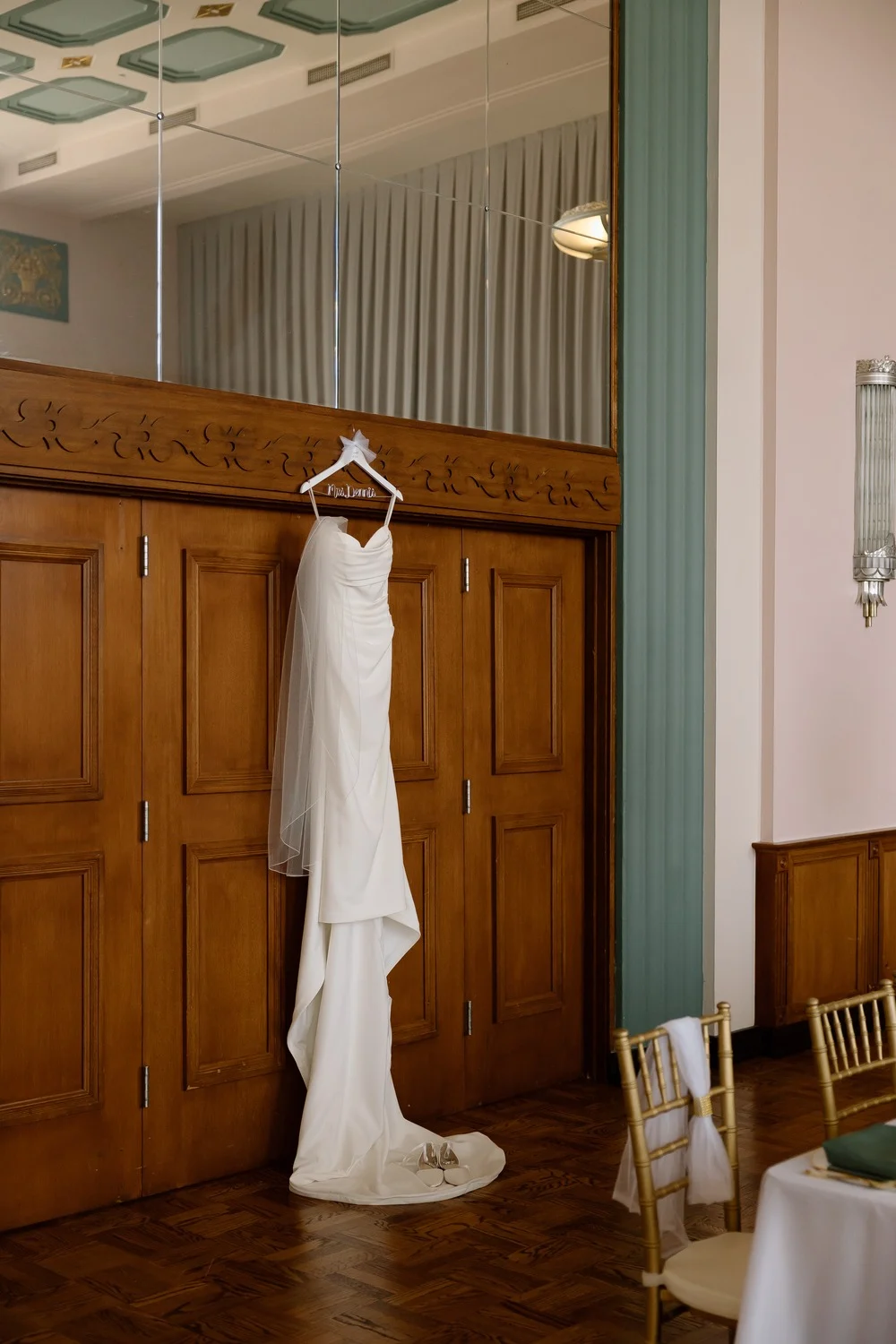 Merribelle’s fitted crepe wedding gown with a long train hanging at the venue