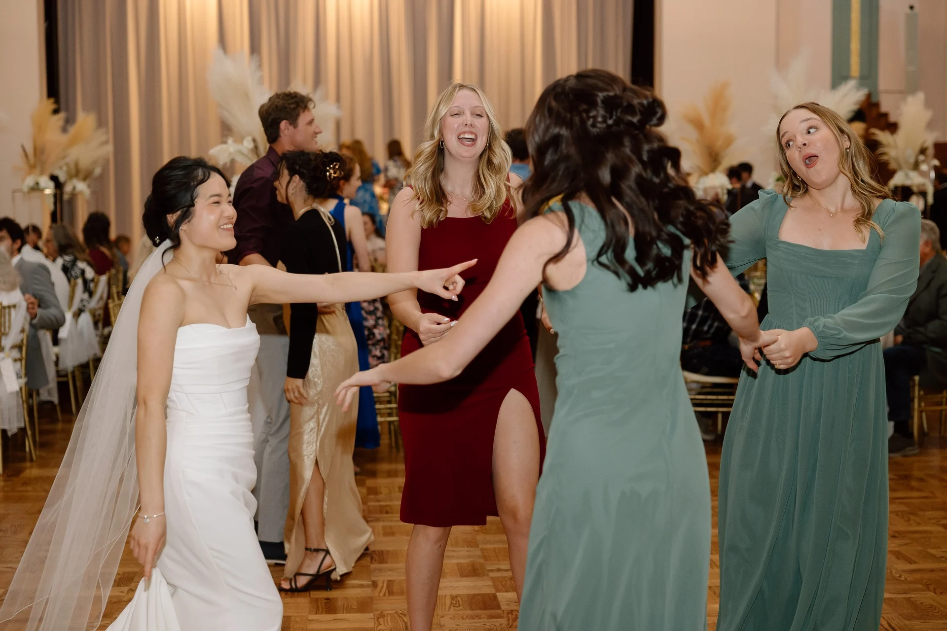 The bride dancing with her bridesmaids on the reception dance floor