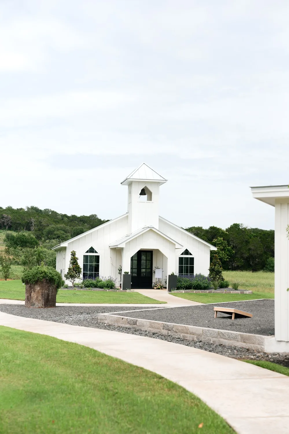 The white chapel and bell tower at Posey Meadows, a wedding venue in San Marcos, Texas