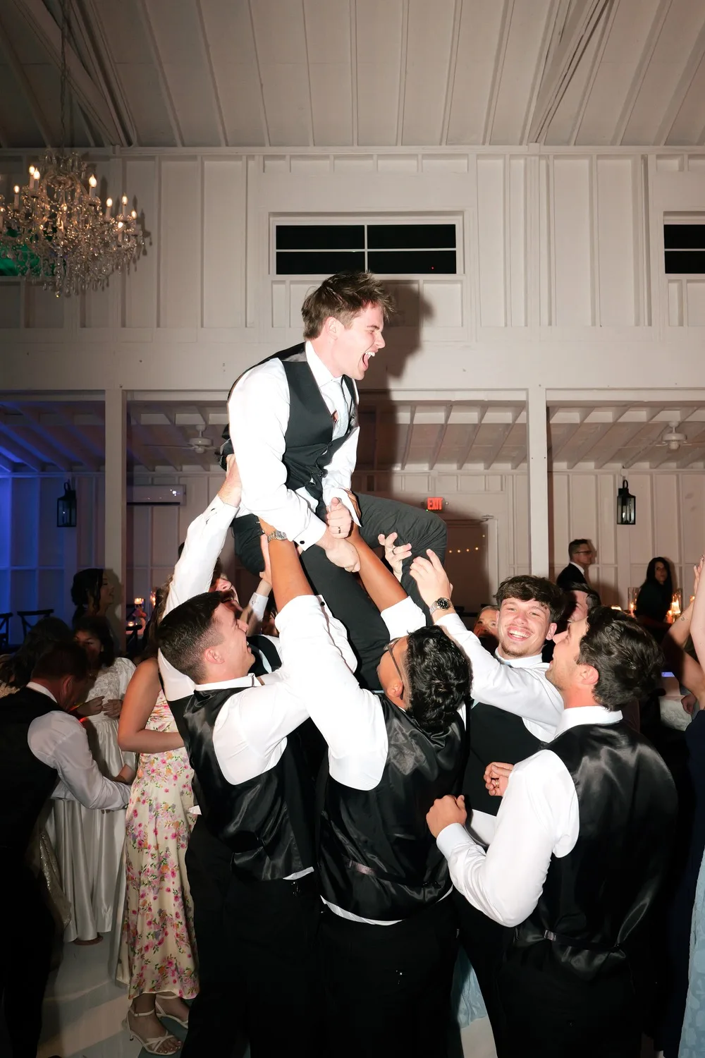 Groomsmen lift Parker into the air on the dance floor during Dancing Queen